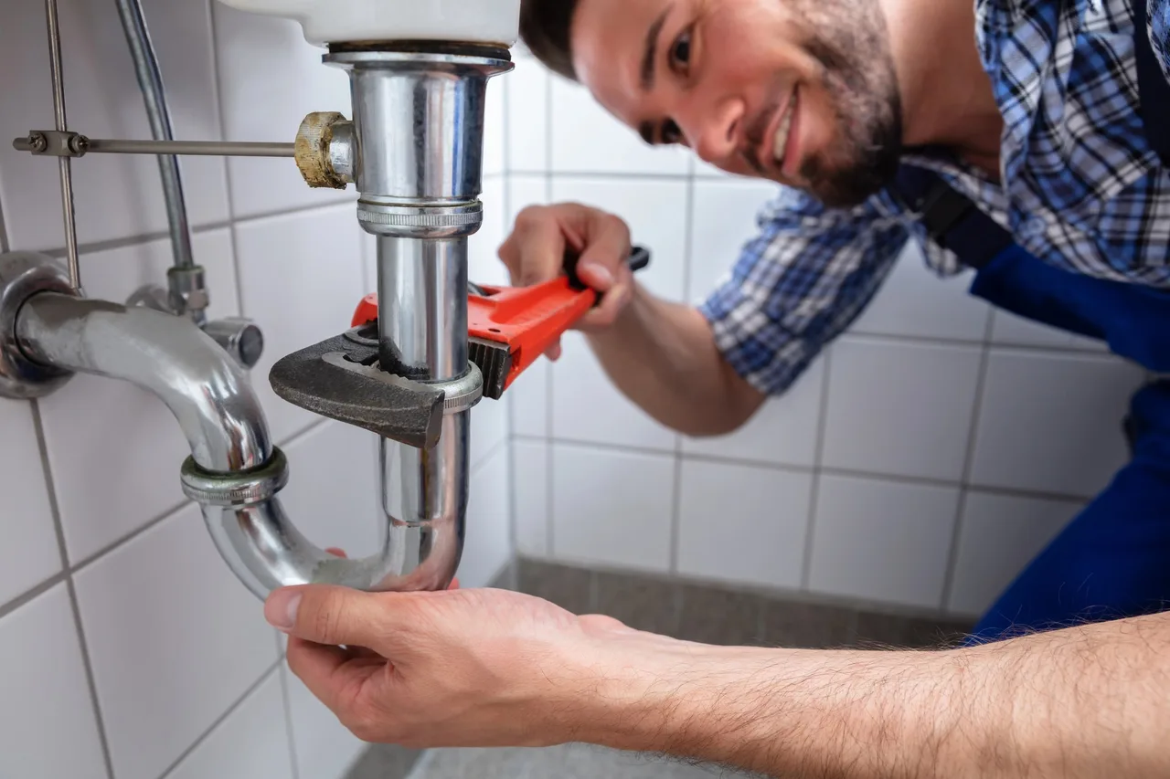 Plombier reprenant le raccordement d'une canalisation dans un immeuble du 13e à Paris